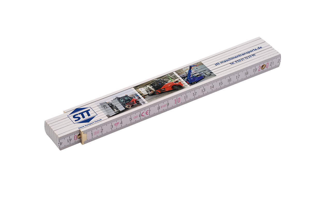 Gefalteter weißer Zollstock mit Zentimeter-Skala und Messinggelenken, bedruckt mit blauem STT-Logo, Firmenwebadresse sowie kleinen Fotos von Gabelstaplern und Transportfahrzeugen.